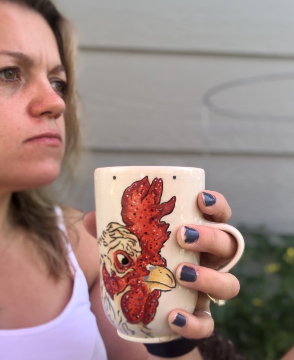 woman holding a mug with a rooster on it