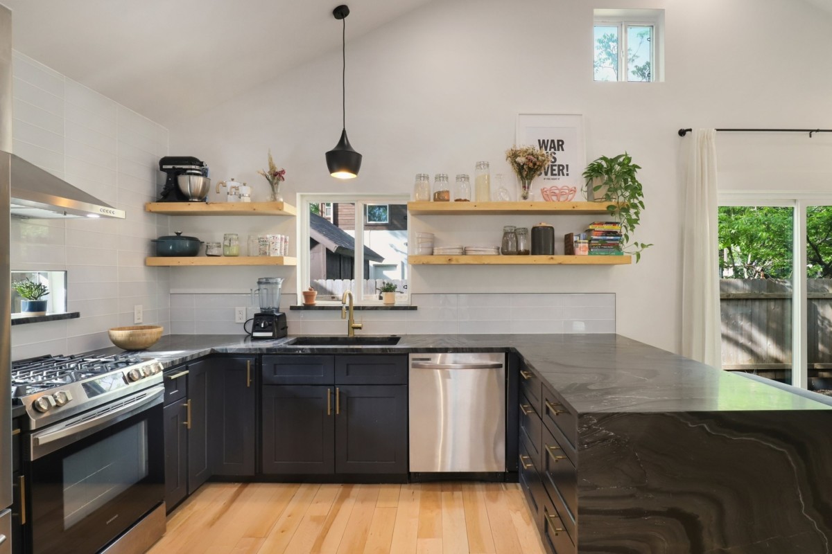 kitchen with lots of open storage space and black counters