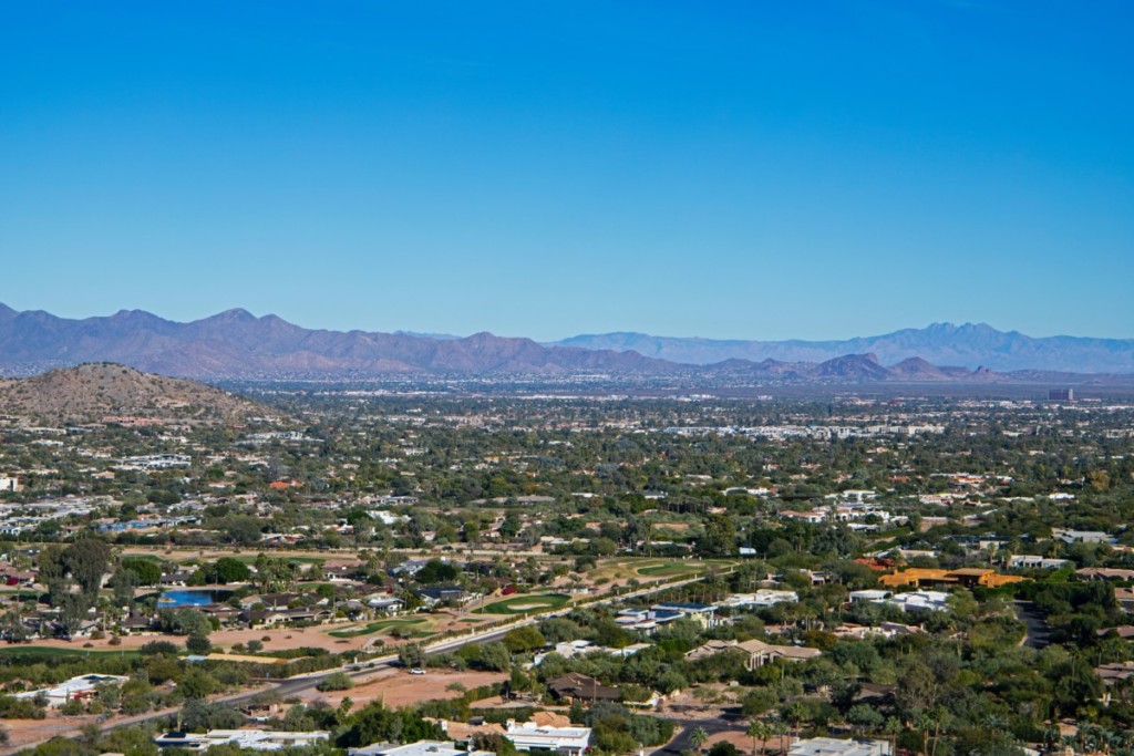 view of cities near mesa from top of camelback mountain on sunny clear day