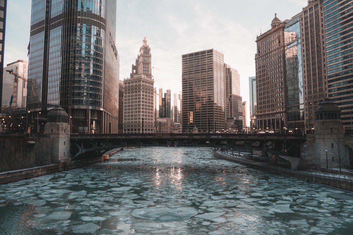 frozen river in chicago with skyline in the background