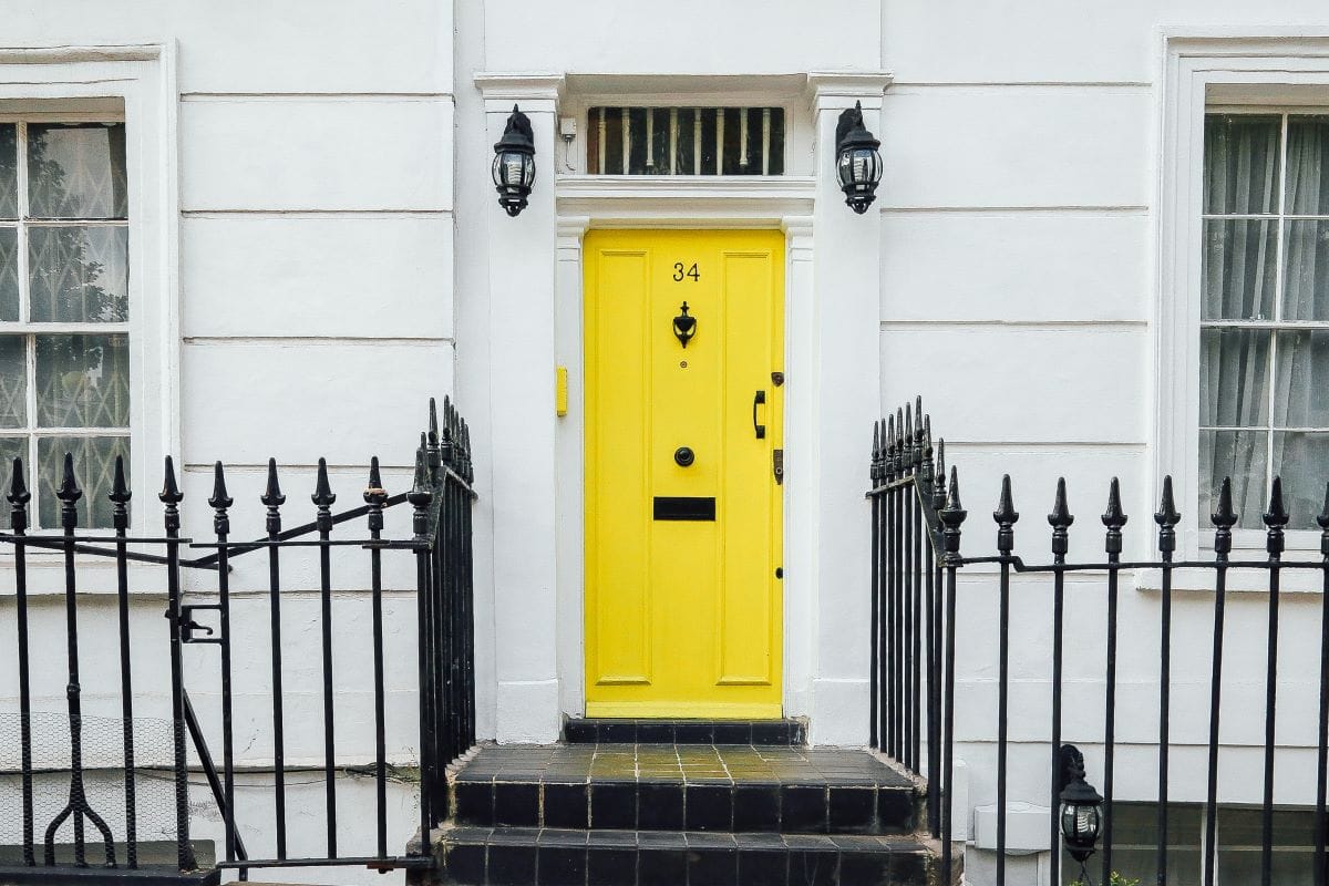 house with a yellow front door and metal gate