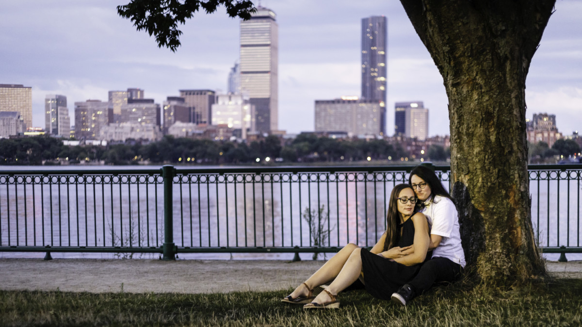 Couple under a tree with the Boston skyline behind