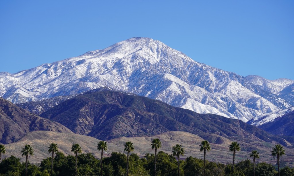 snowy mountains in background of redlands, california on a sunny day