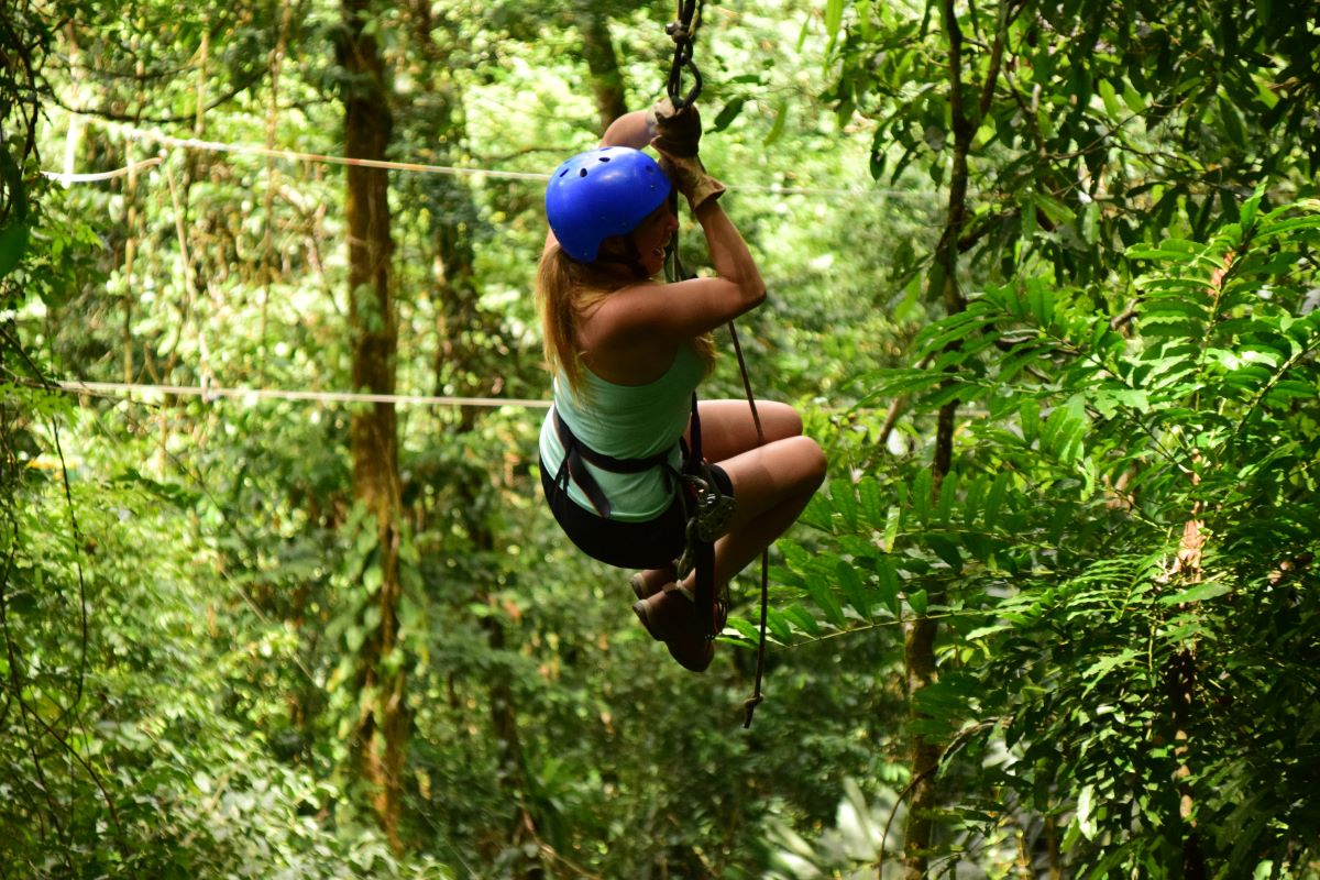 person ziplining in a forest