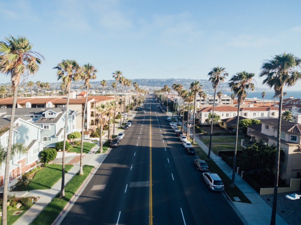 aerial view of redondo beach street on sunny day with palm trees along street