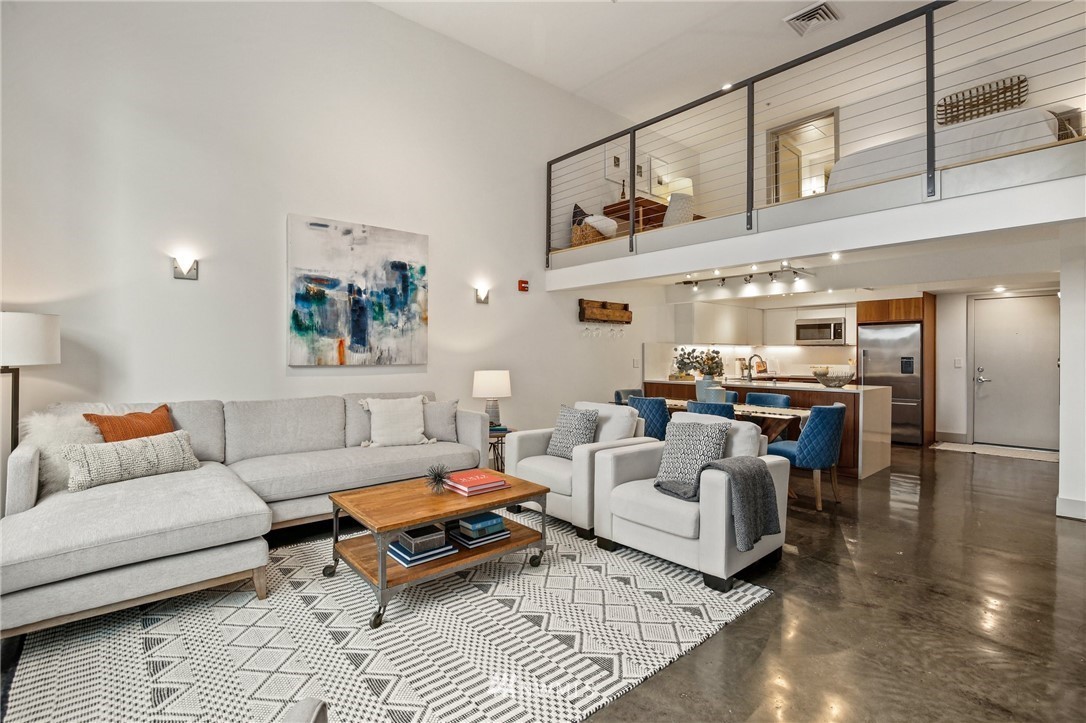living room with open kitchen space and bedroom loft