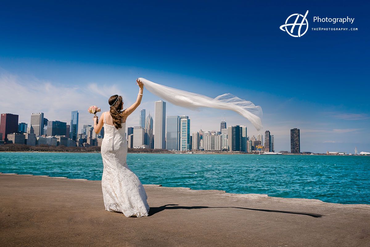 A bride throwing her veil with Chicago down  her
