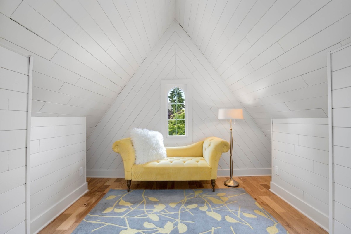 attic space with a chaise lounge and lamp