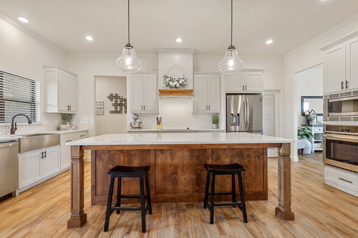 Large country kitchen in a farmhouse with white walls and exposed wood