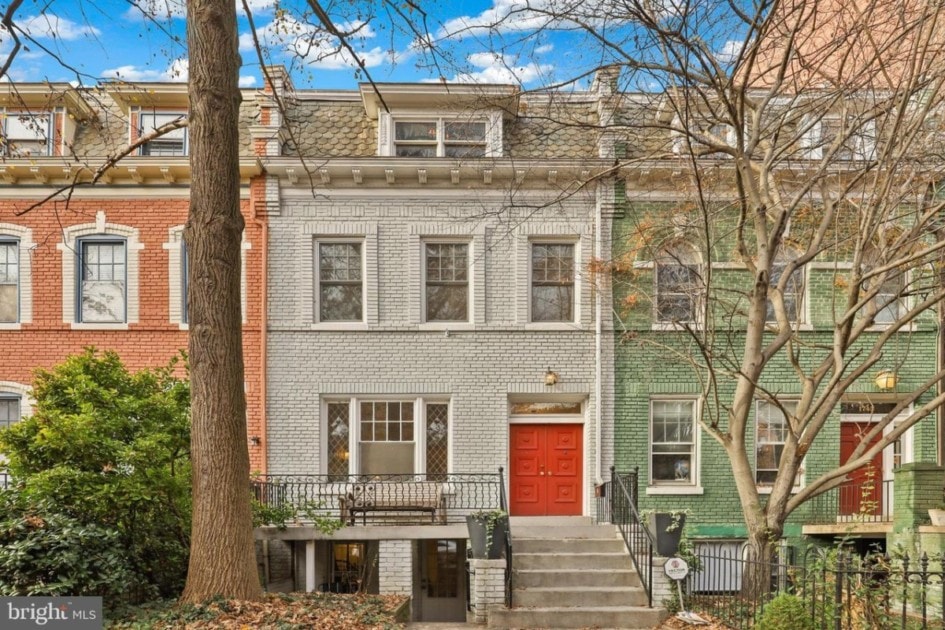 Two-story, white brick painted townhouse with red door for sale in Adams Morgan