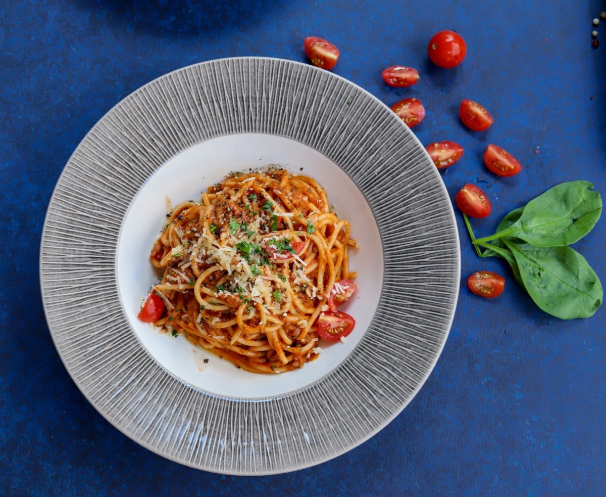 pasta pomodoro on a table with tomatoes and basil