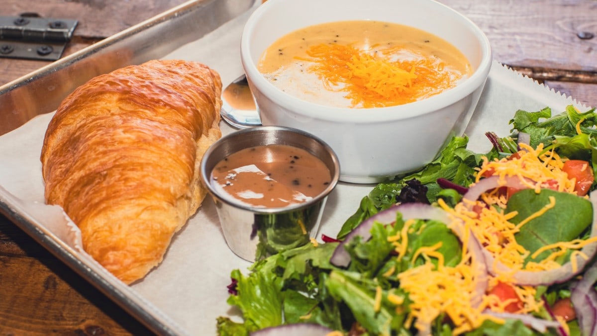 soup and salad with croissant on a plate