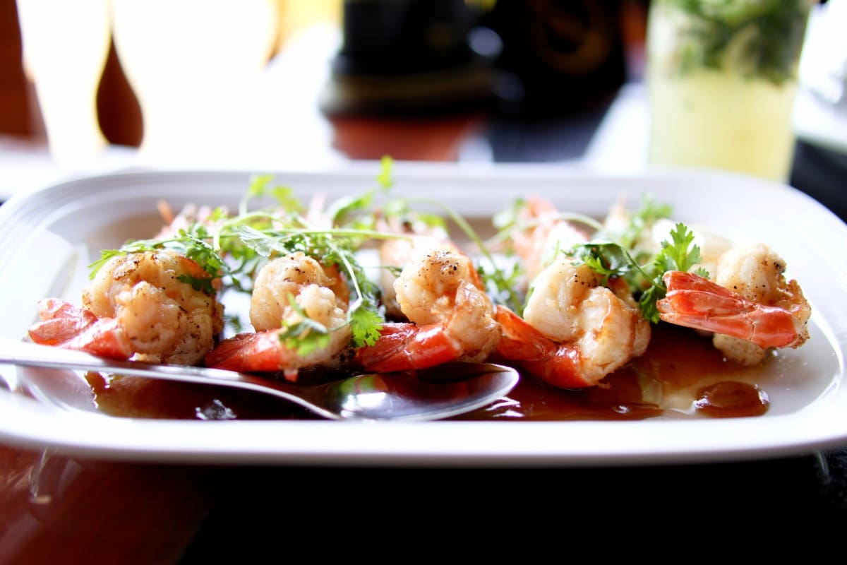 grilled shrimp on a plate with sauce