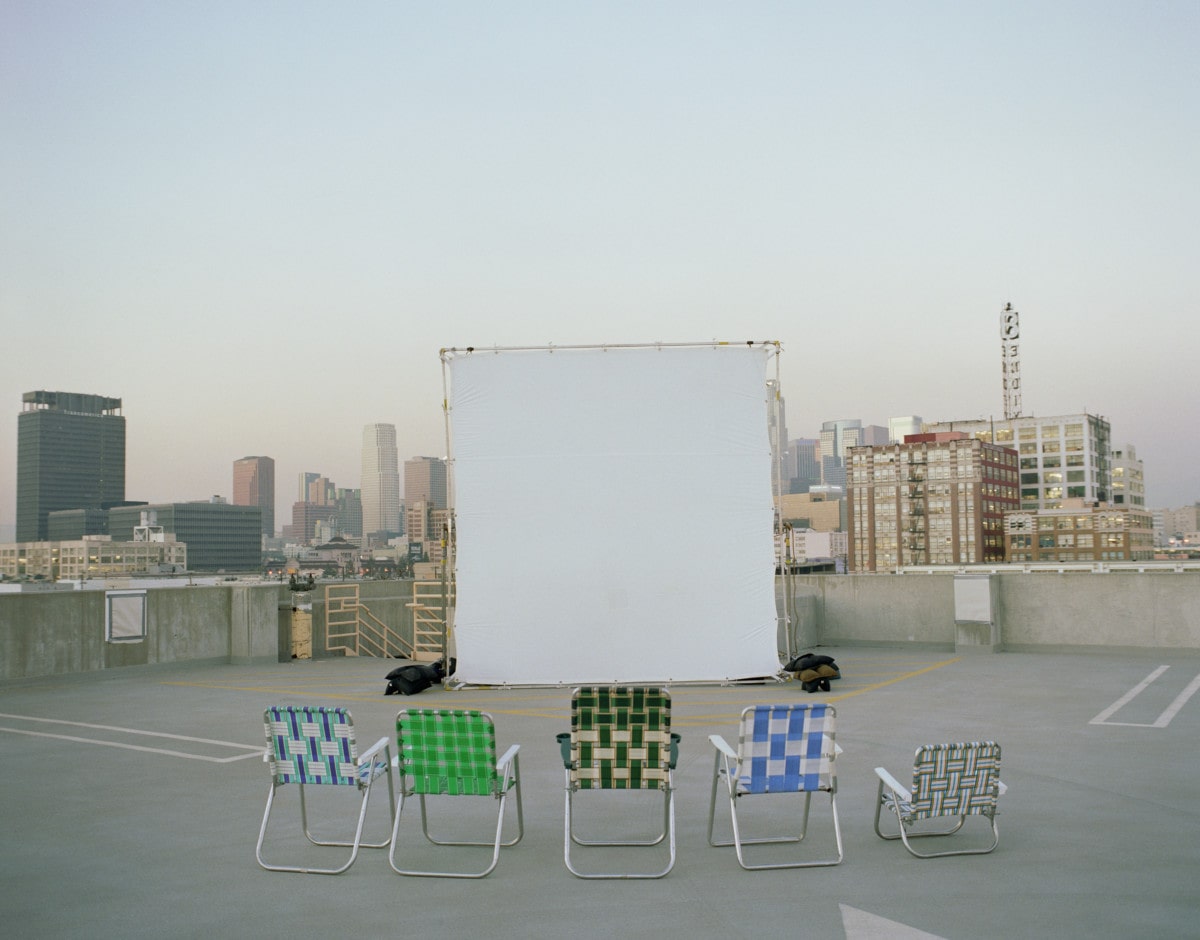 Folding chairs sitting in front of projection screen on rooftop in Los Angeles _ getty