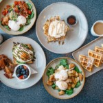 breakfast dishes like eggs and waffles on a table