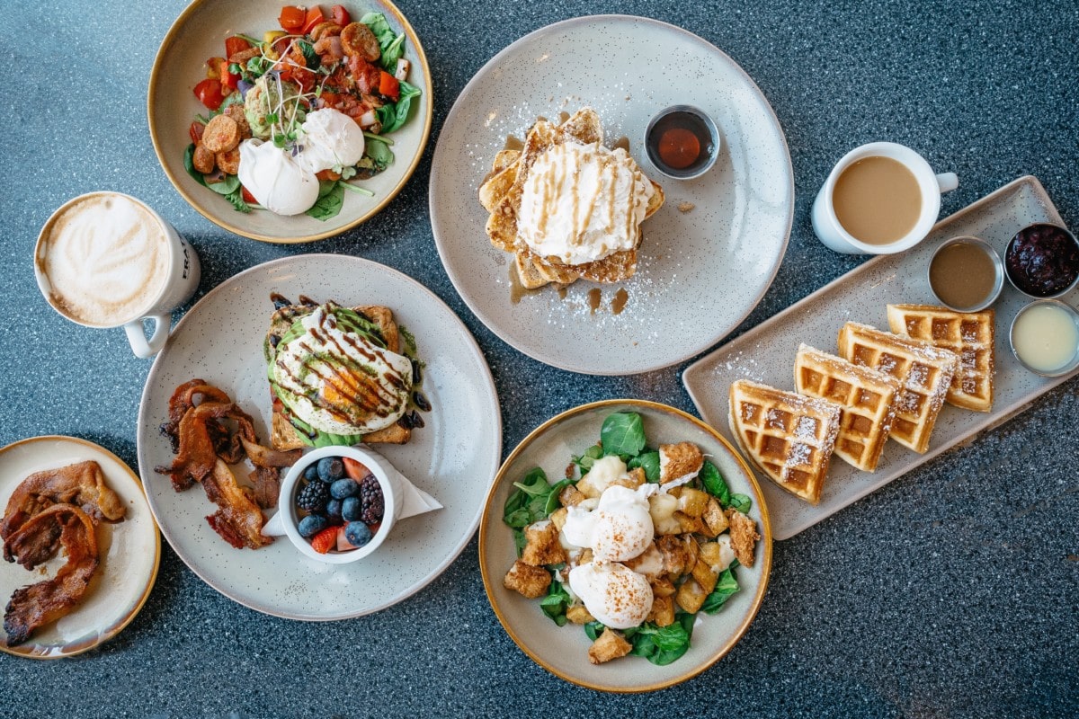 breakfast dishes like eggs and waffles on a table