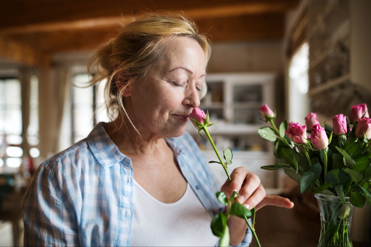 A lady smelling a rose