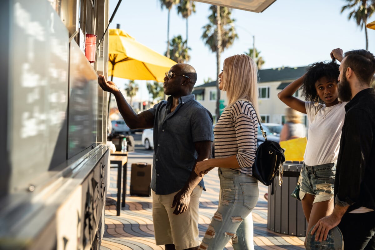 Friends buying food in a street food truck _ getty