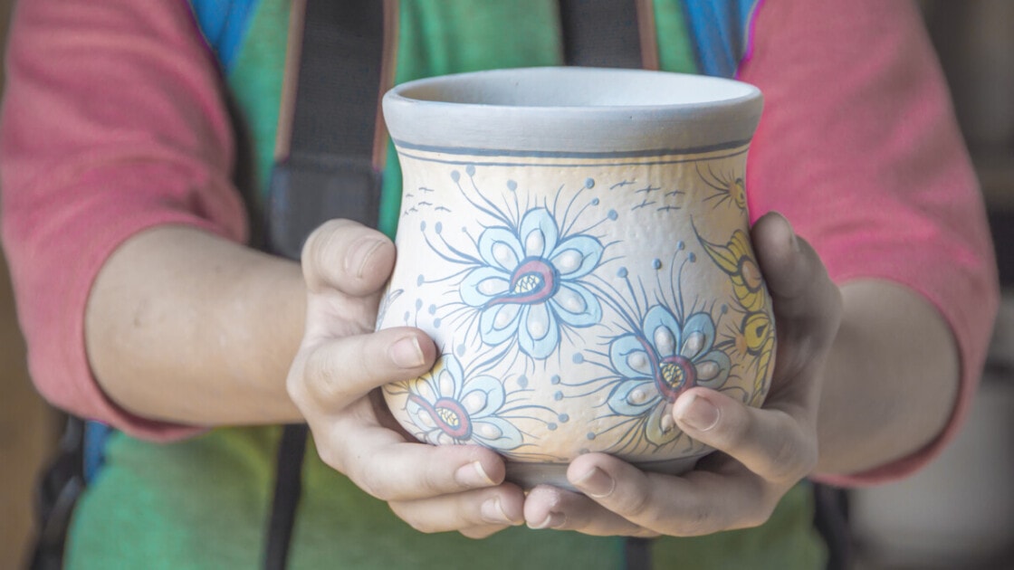 Boy holding mayan pottery connected hands