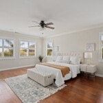 spacious primary bedroom with new blinds and hardwood floors