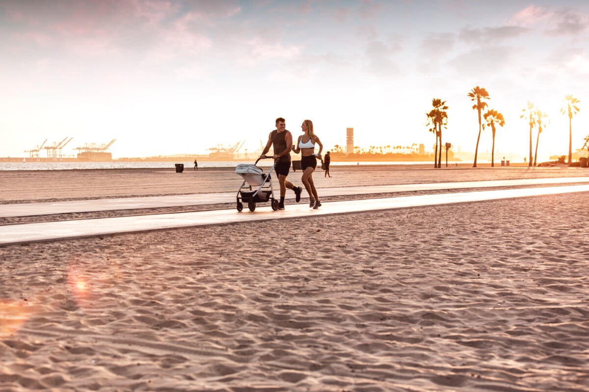 Amazing modern and young family running on the beach at sunset _ getty