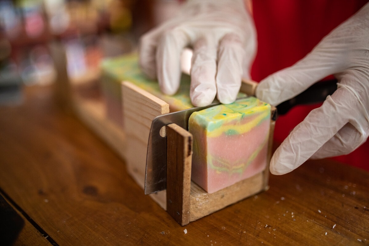 Woman cutting soaps from natural oils at home workshop