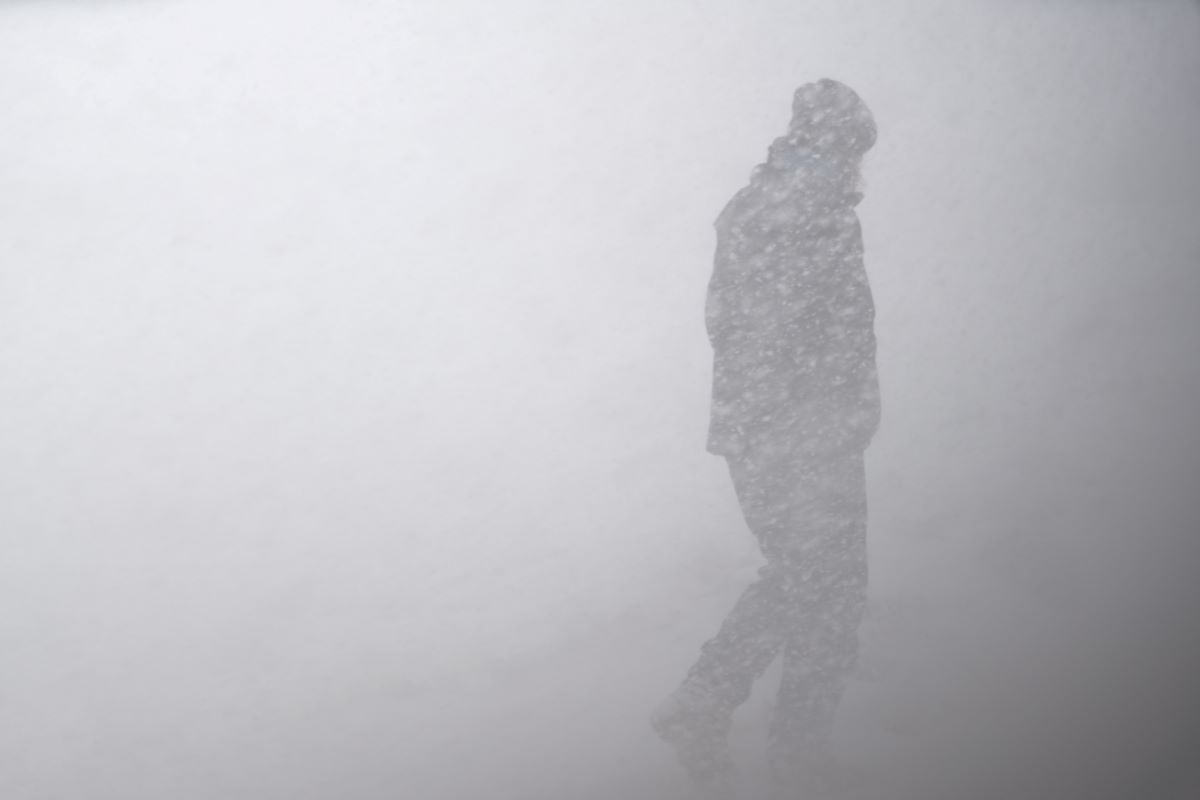person walking through a snowstorm