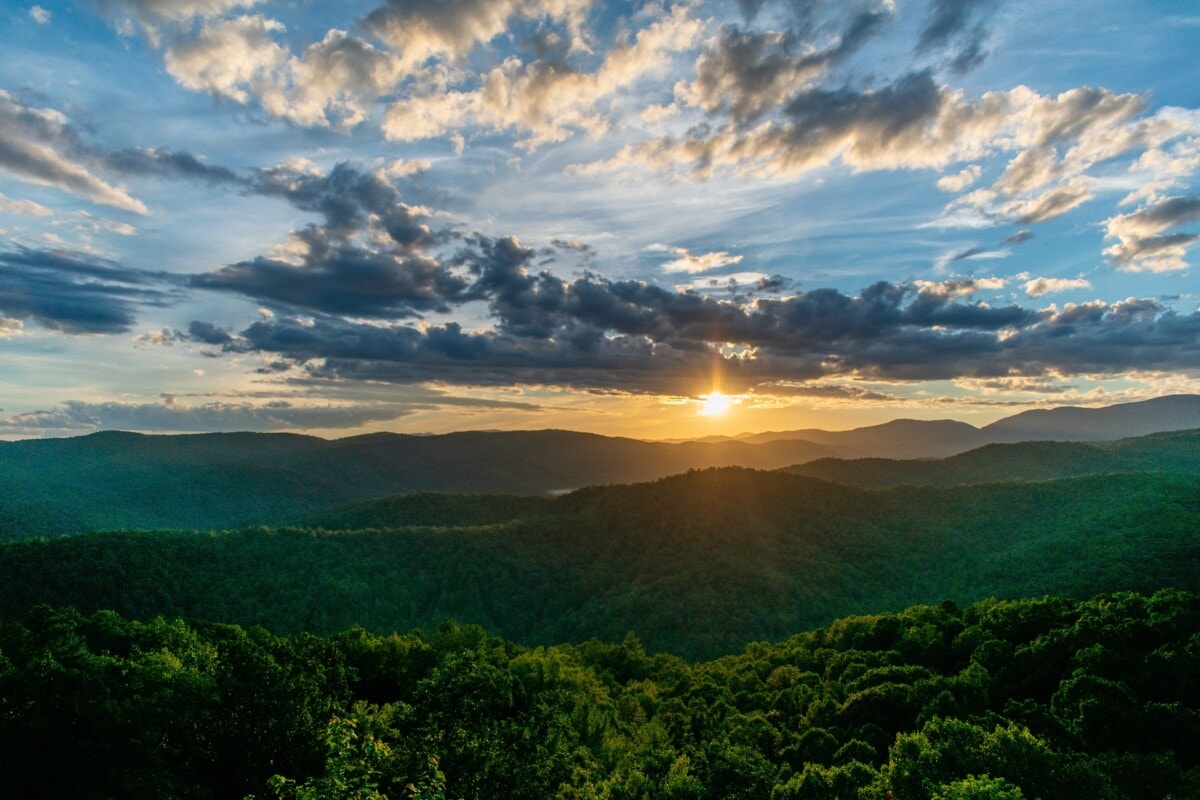 hills in north carolina with sun and clouds