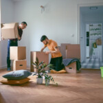 Couple unpacking cardboard boxes and moving in a new home