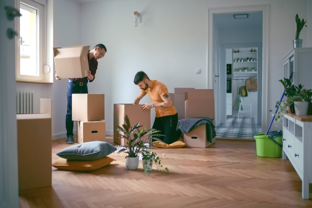 Couple unpacking cardboard boxes and moving in a new home