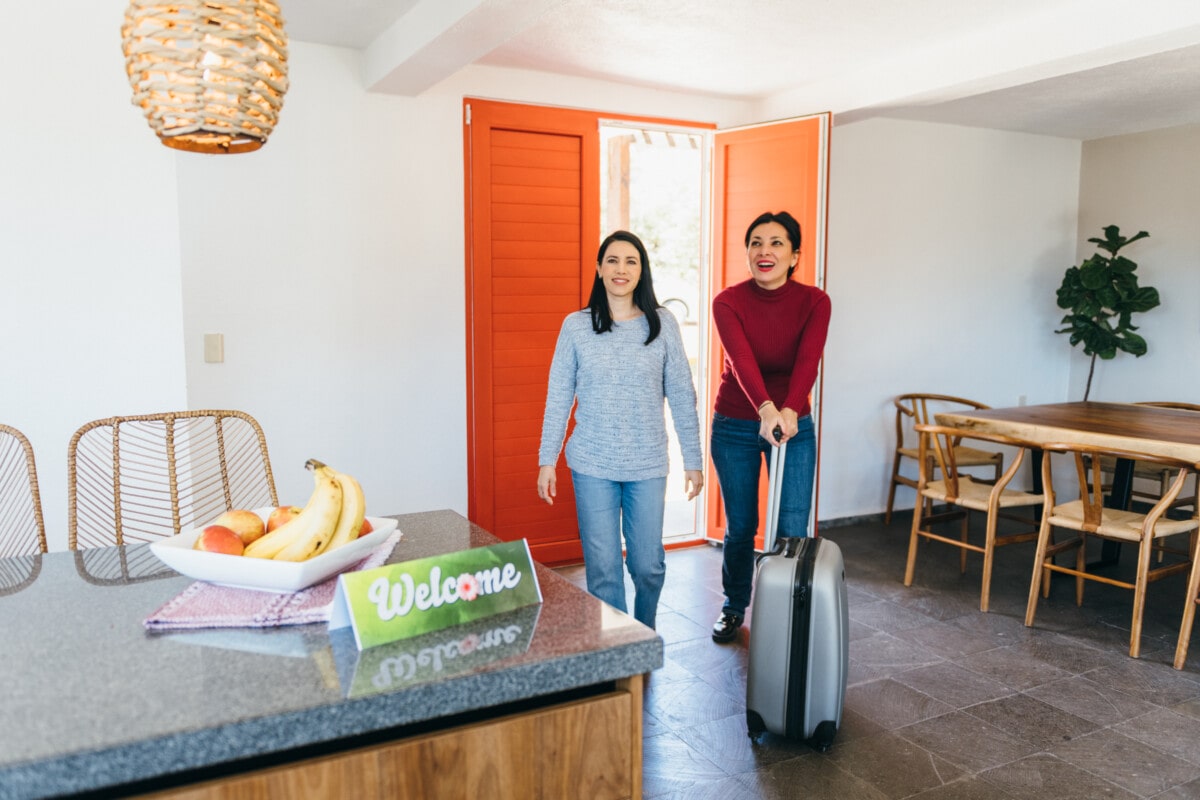 New tenants arriving at vacation rental pushing  luggage