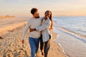 Couple walking at beach during sunset