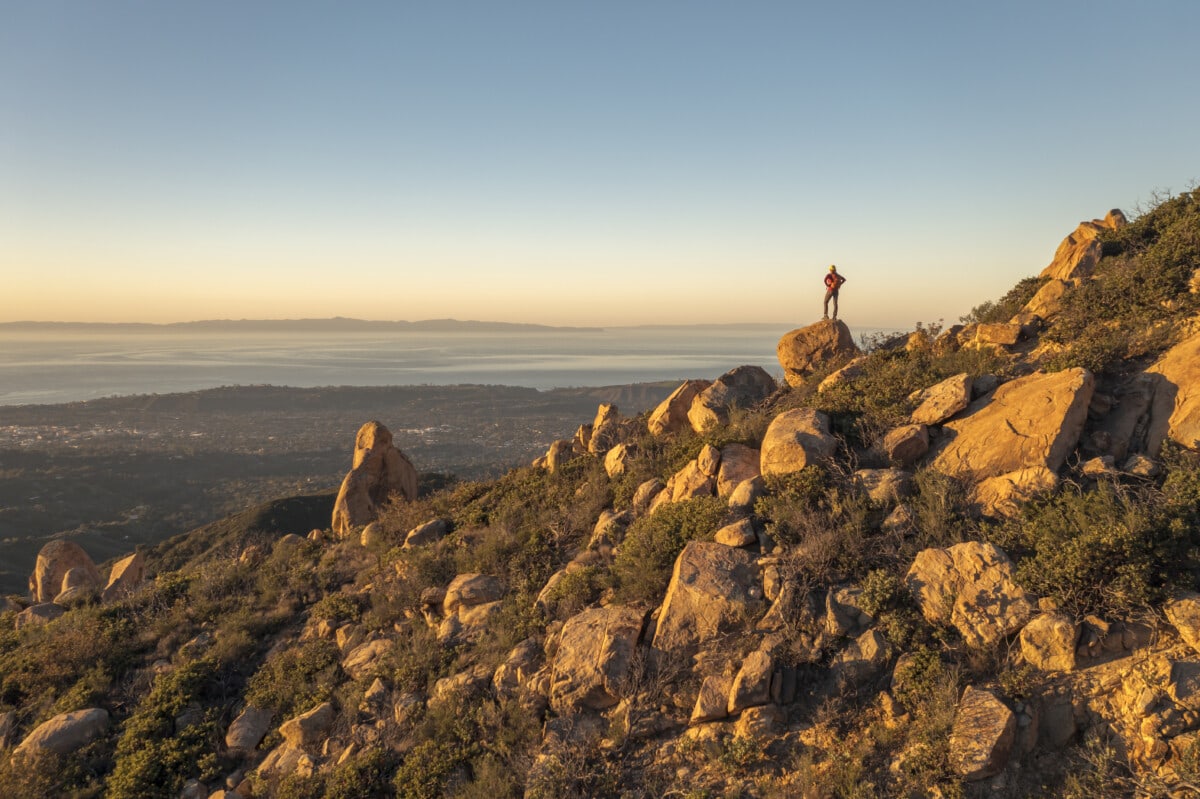 A woman hiker on the trail to Cathedral Peak in the Santa Ynez mountains high above Santa Barbara with views to the Channel Islands.