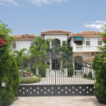 Mansion behind a gate surrounded by tropical greenery _ getty