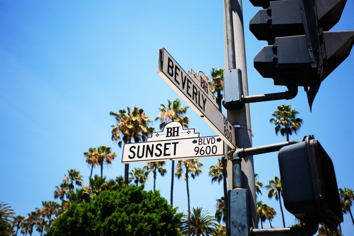Sunset and Beverly Road Sign With Palm Trees In Background