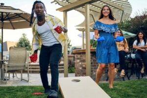 people playing cornhole in a backyard