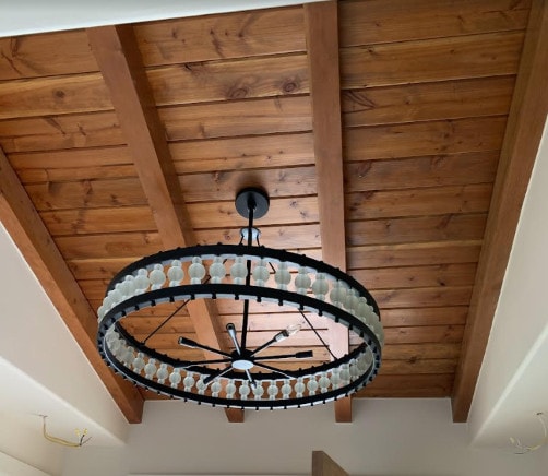Spanish style ceilings featuring craft wood, beams, and a chandelier 