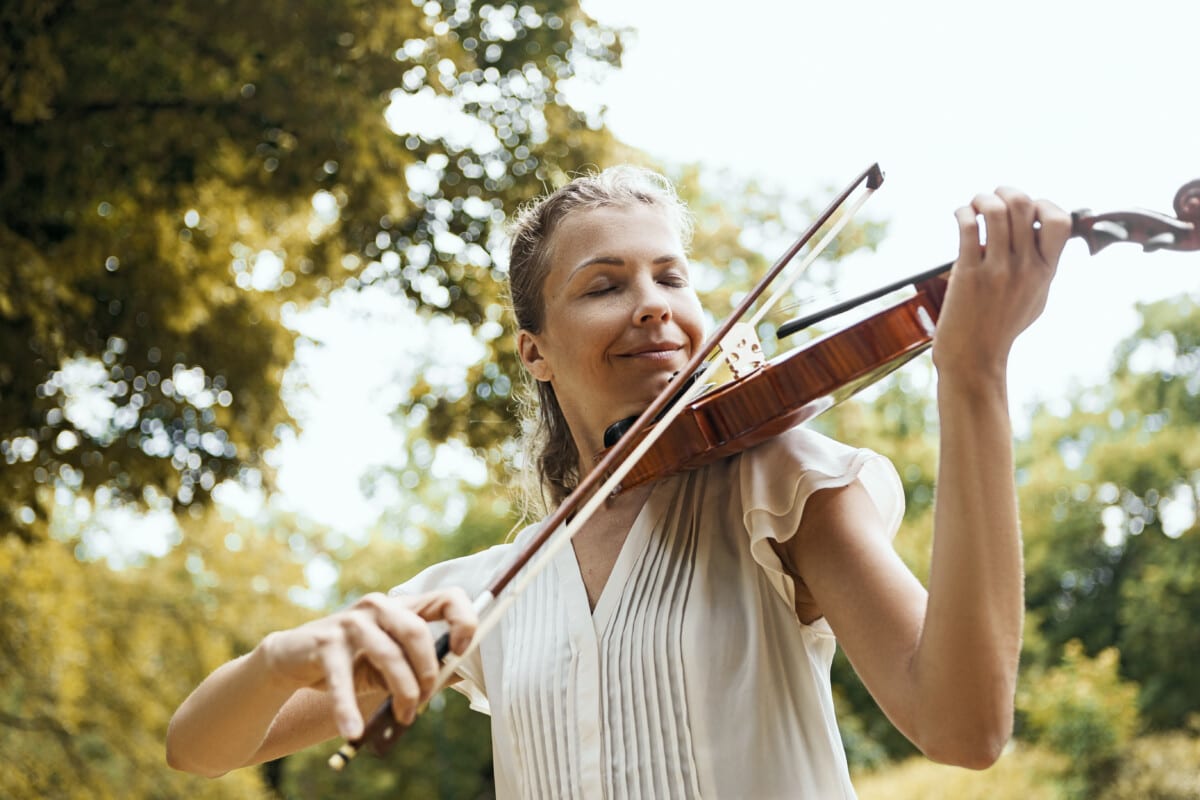 Woman playing the violin outdoors