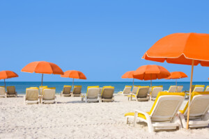 White sandy beach with lounge chairs and orange umbrellas
