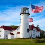 lighthouse with american flag in chatham ma