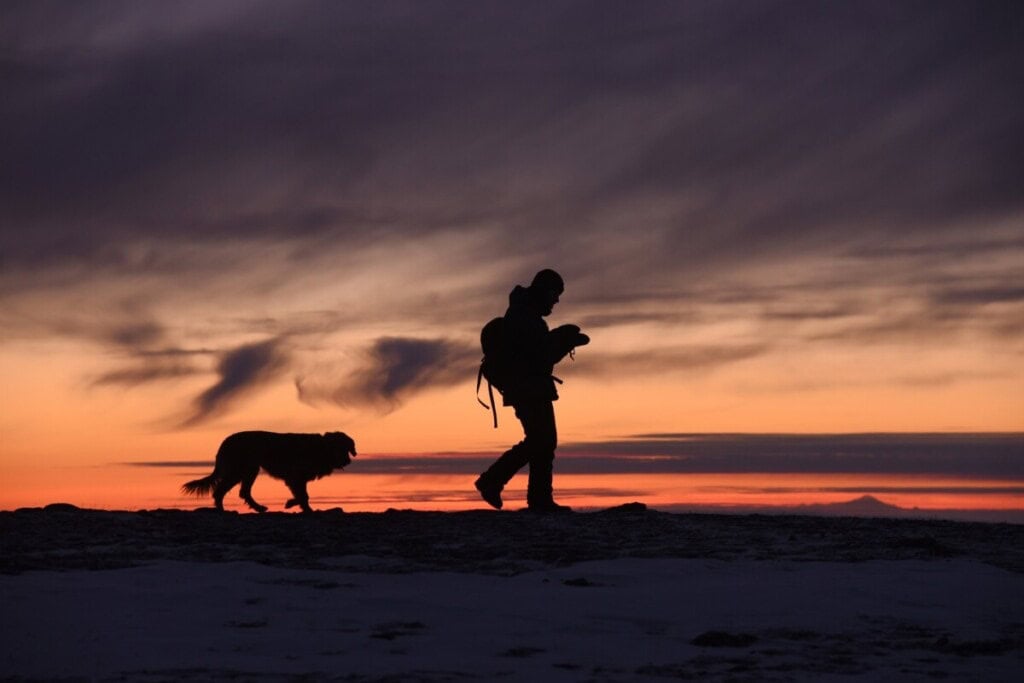 A man with a dog behind him