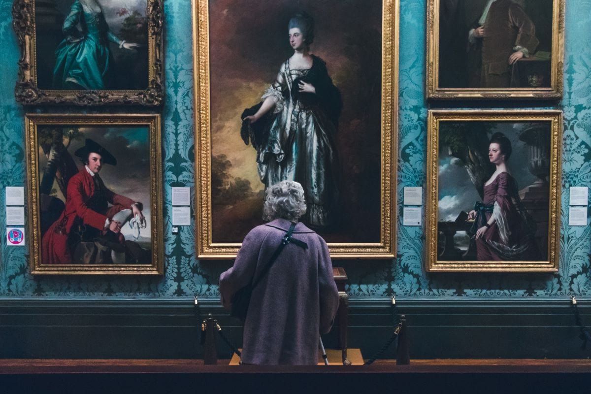 person viewing paintings in a museum