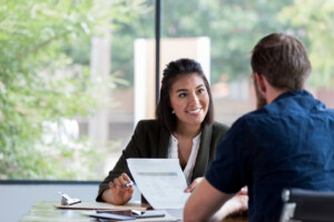 businesswoman smiles portion    showing a papers  to a antheral  associate.