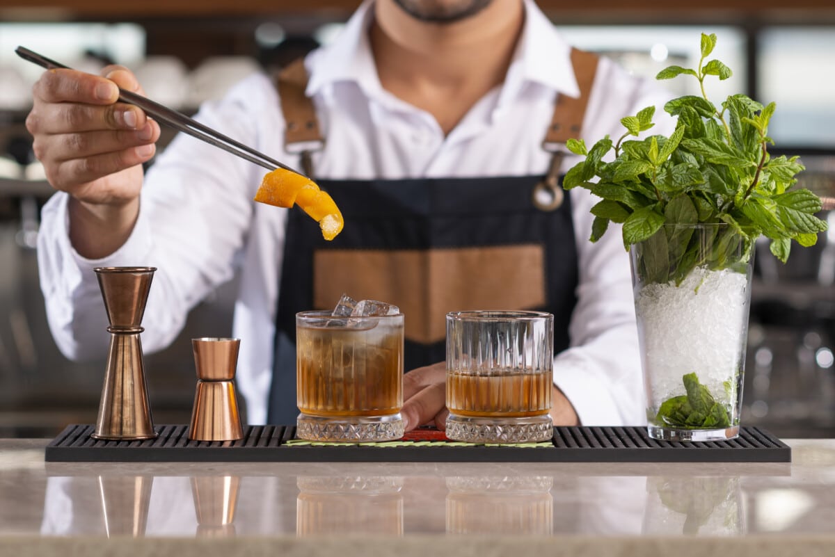 Bartender adding lemon peel in a drink