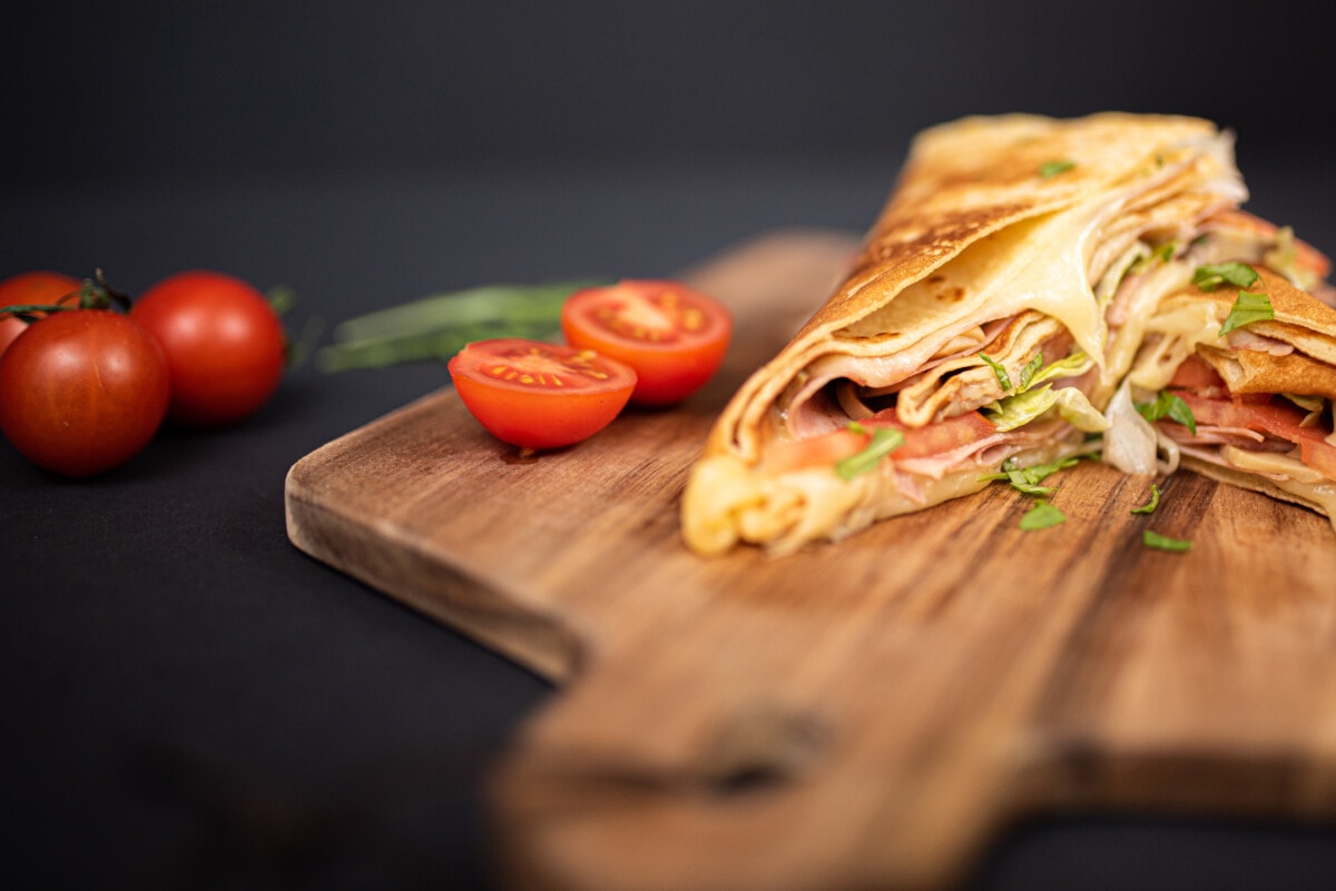 Crepes, thin pancakes with ham, cheese, mushrooms and tomatoes.