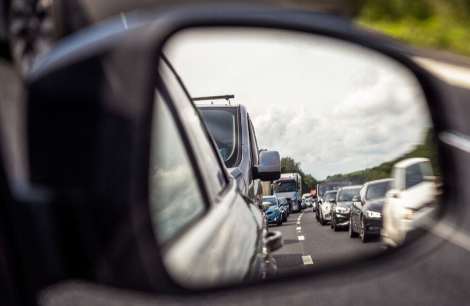Looking back at traffic jam through rearview mirror