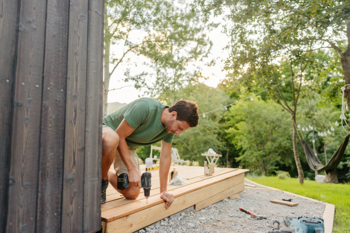 Carpenter installing decking boards _ getty