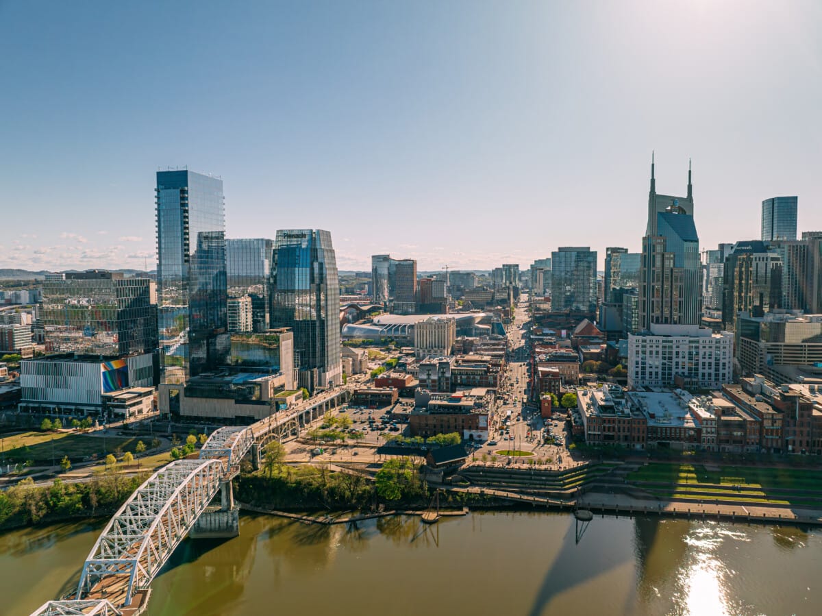 Aerial View of Broadway, the Tourism Center of Downtown Nashville, Tennessee on a Sunny Springtime Afternoon from the North Side of the Cumberland River near Nissan Stadium