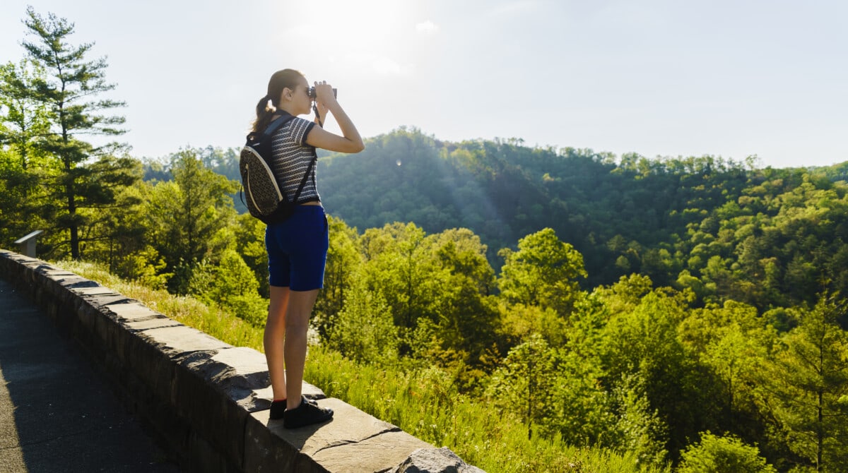 woman with binoculars looking at the Great Smoky Mountains