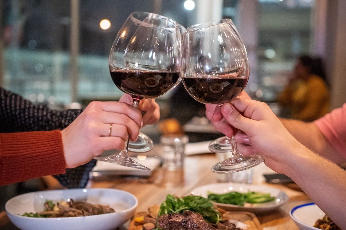 people holding wine glasses at a table